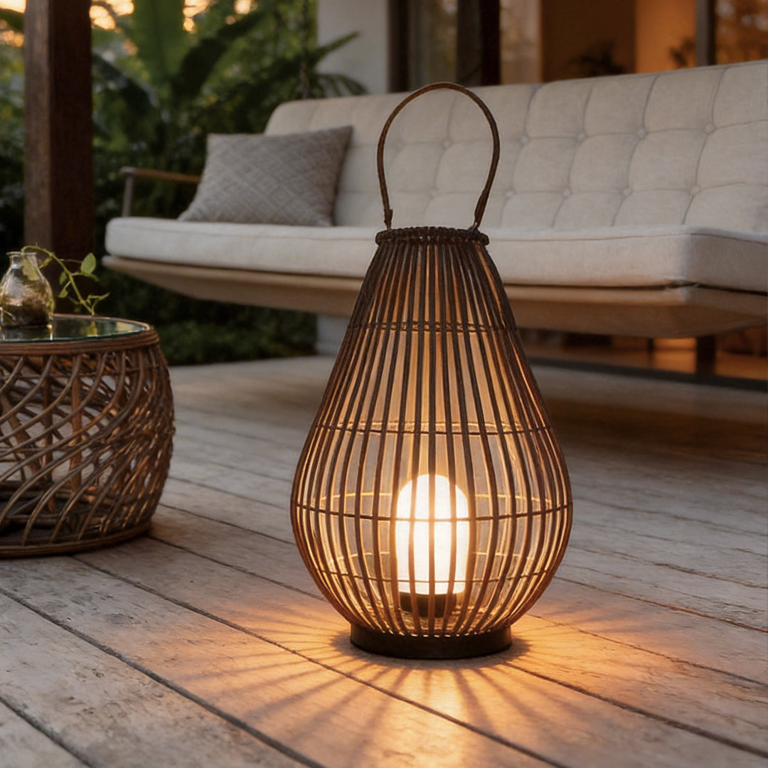 Woven bamboo lantern with a natural finish, providing warm illumination on a wooden deck.