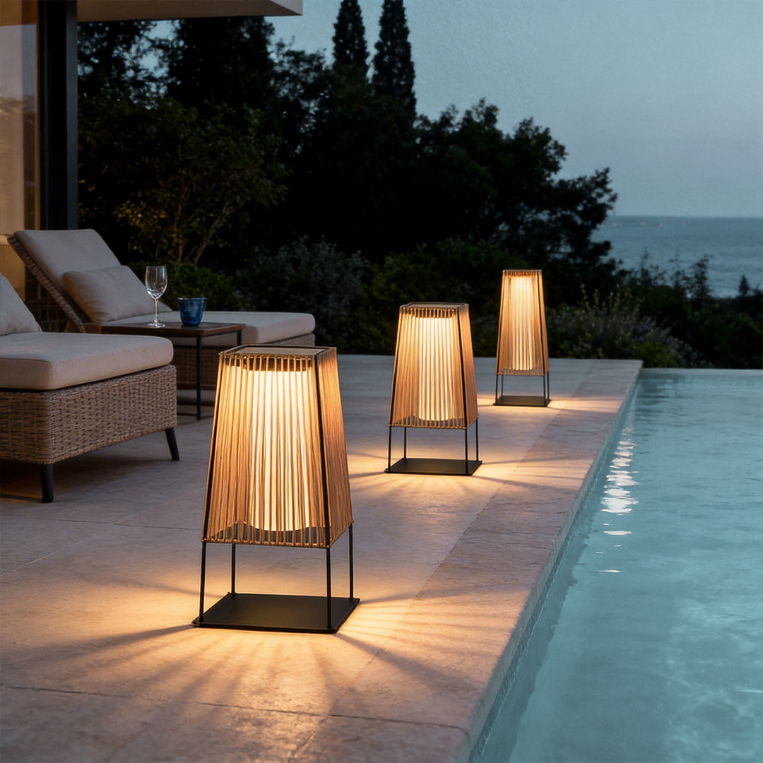 Woven floor lamp with a sleek design, enhancing a poolside patio at dusk.