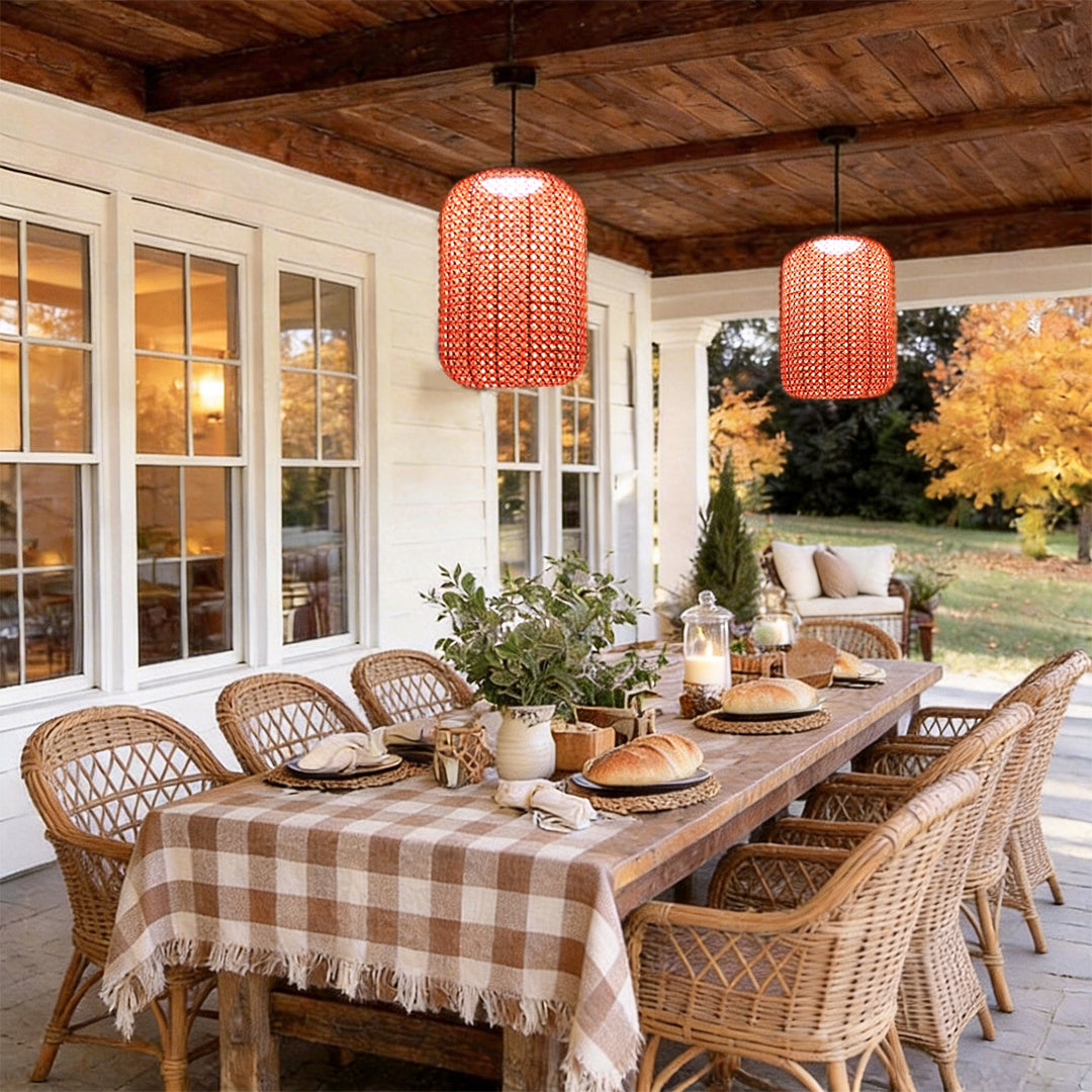 Woven hanging lantern with a red woven design, providing warm illumination above an outdoor dining table.