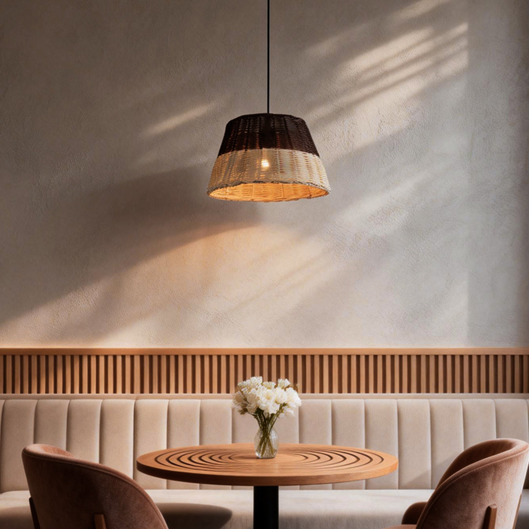 Woven pendant lamp illuminating a modern dining area with warm, natural glow.