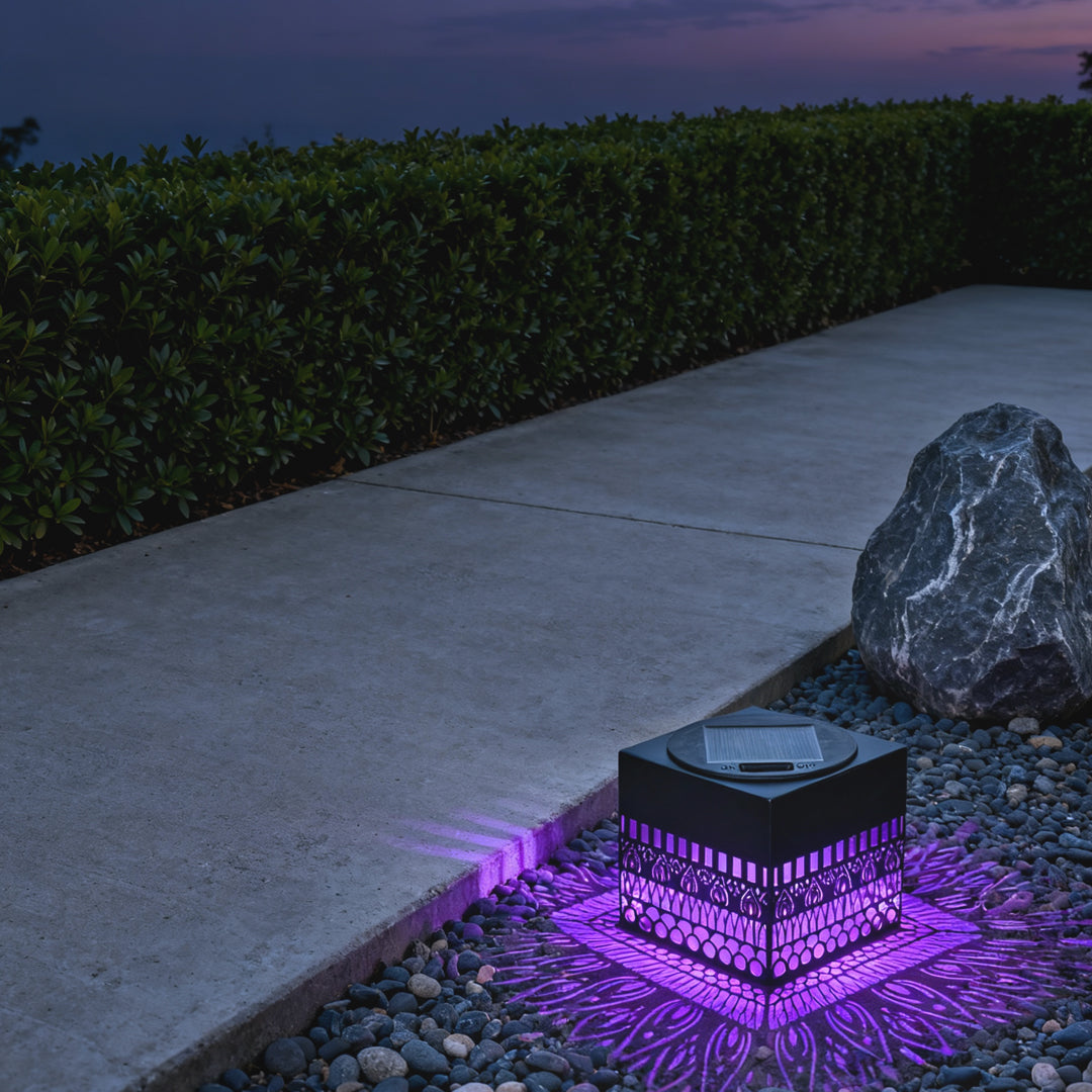 Pathway accented by colorful LEDs surrounding a wrought iron outdoor wall lights–inspired decorative cube with warm center glow.