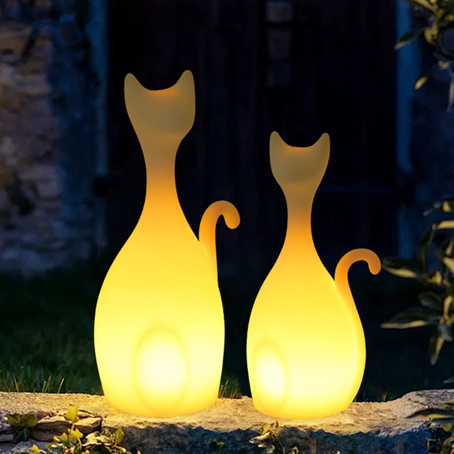 Pair of glowing yellow cat silhouette lights providing warm outdoor decoration at night