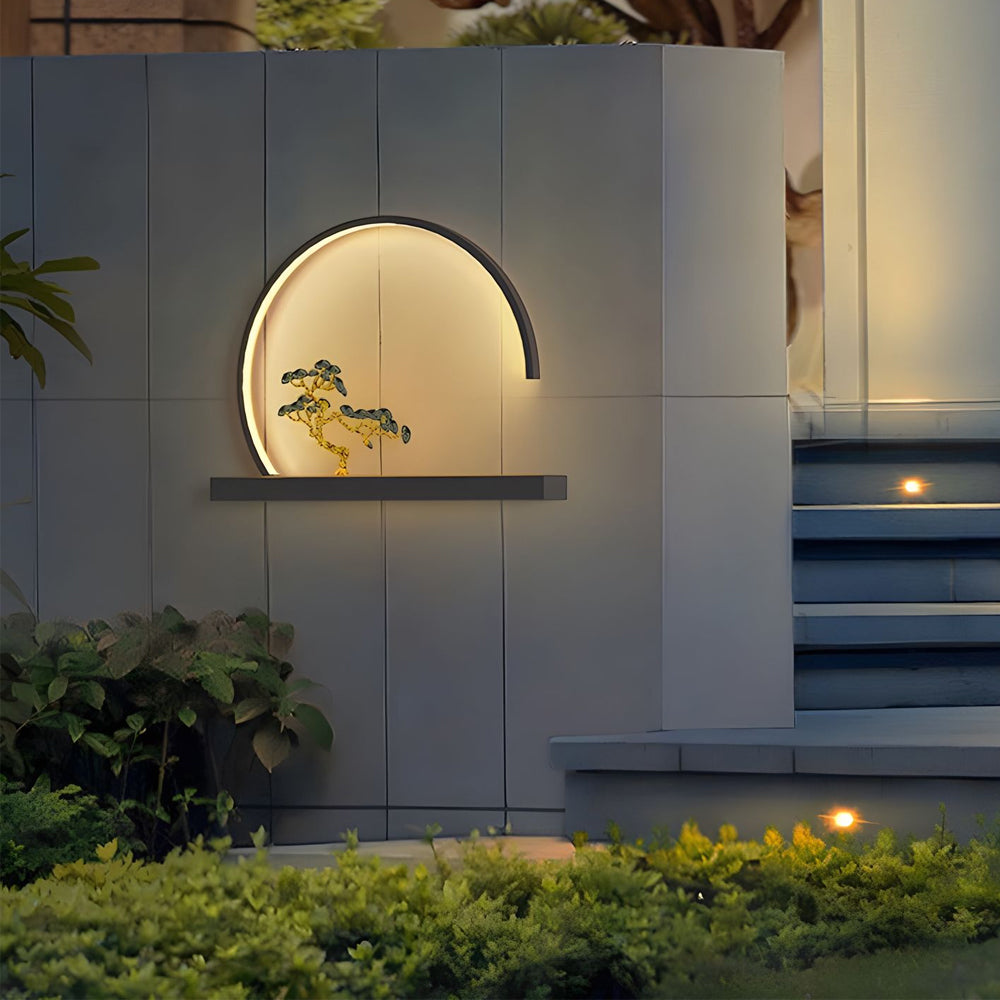 Zen-inspired circular wall light with warm LED glow highlighting miniature tree design in residential interior setting