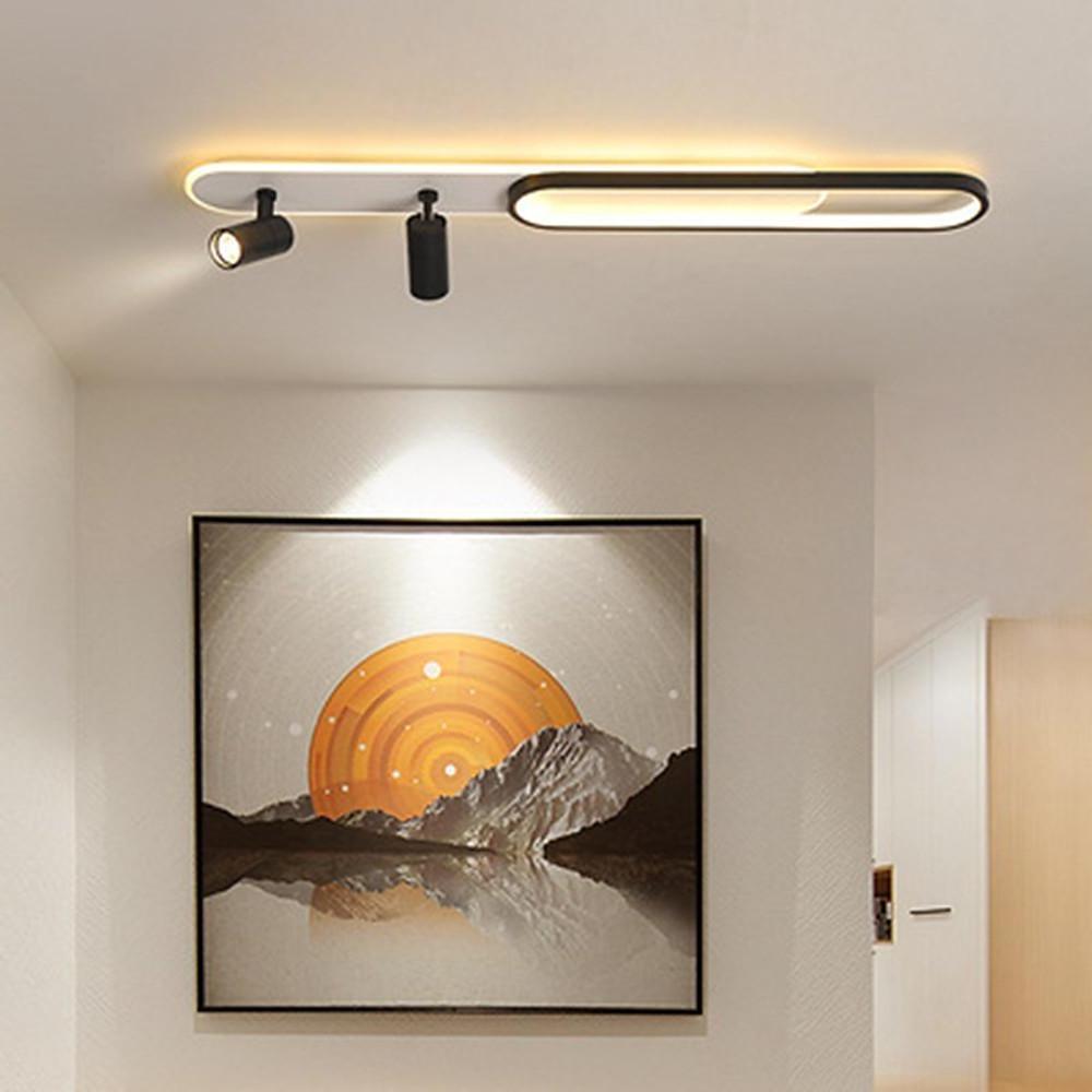 Modern adjustable spotlights on ceiling highlighting wall art with linear LED light.