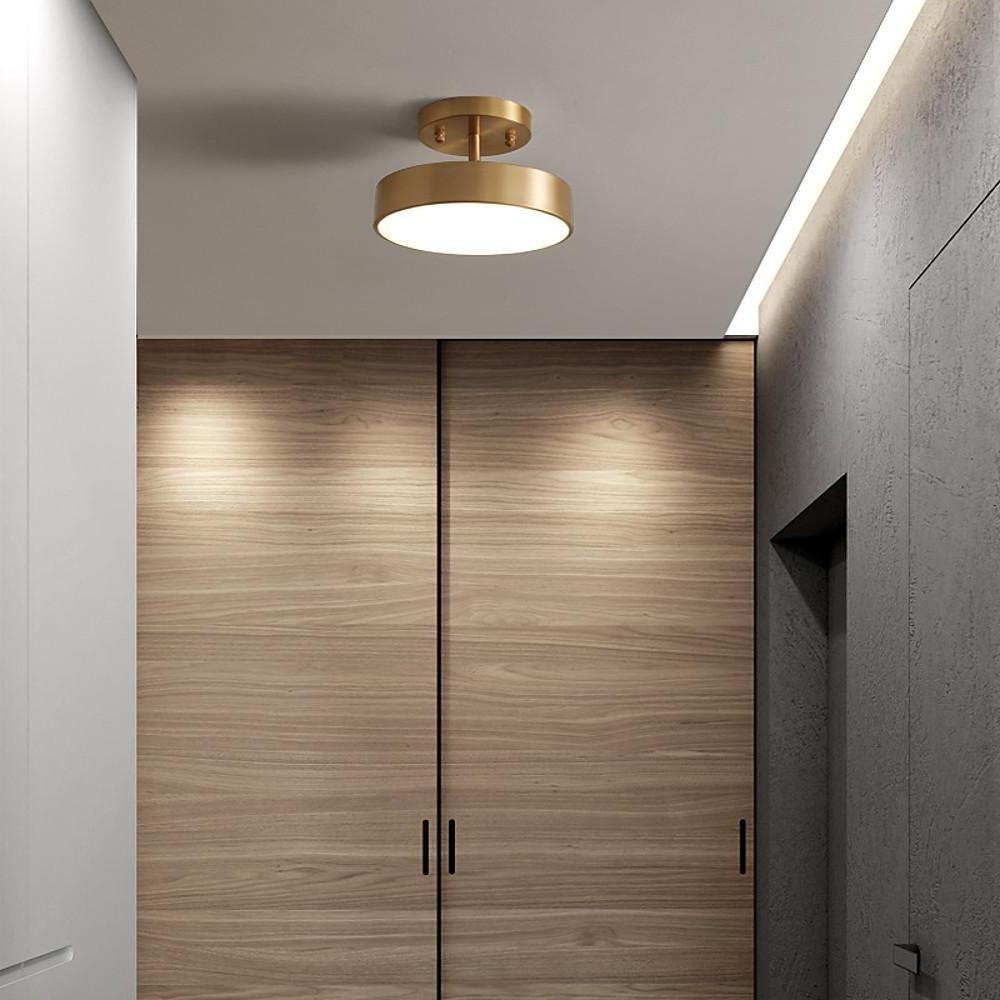 Modern adjustable LED ceiling light installed in a hallway with wood panel walls.