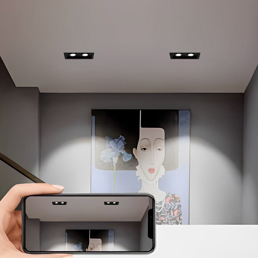 Handheld view of adjustable twin ceiling spotlight with compact recessed housing.
