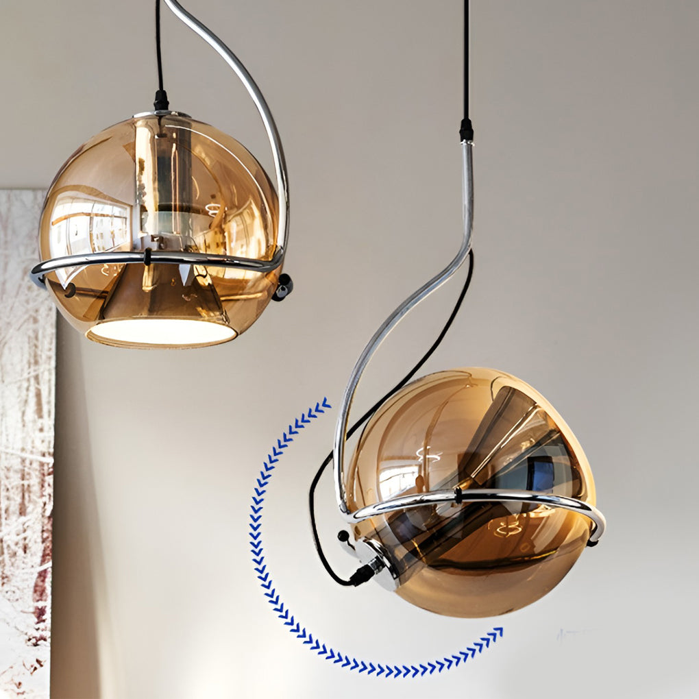 Amber glass globe pendant light installation detail showing adjustable hanging cable and curved metal support.