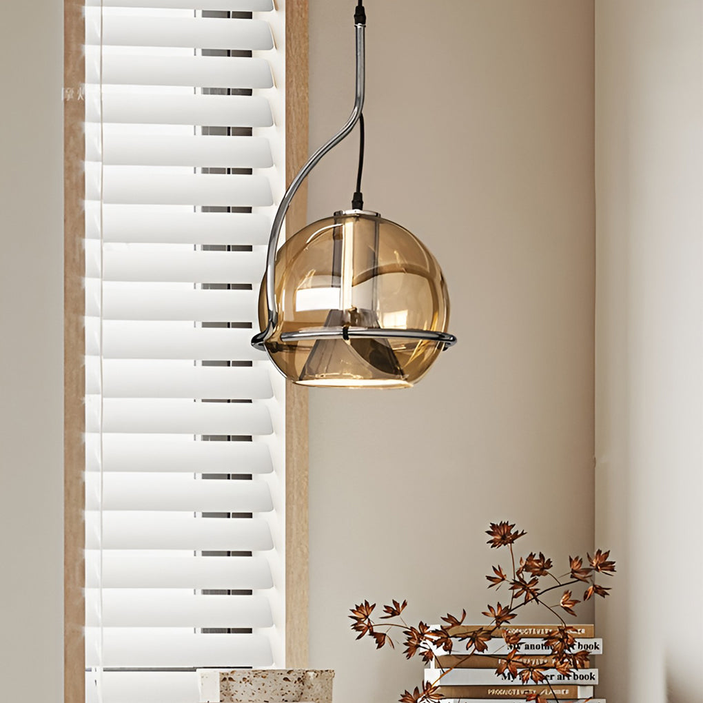 Amber glass globe pendant light suspended in a minimalist living space, adding soft decorative lighting.