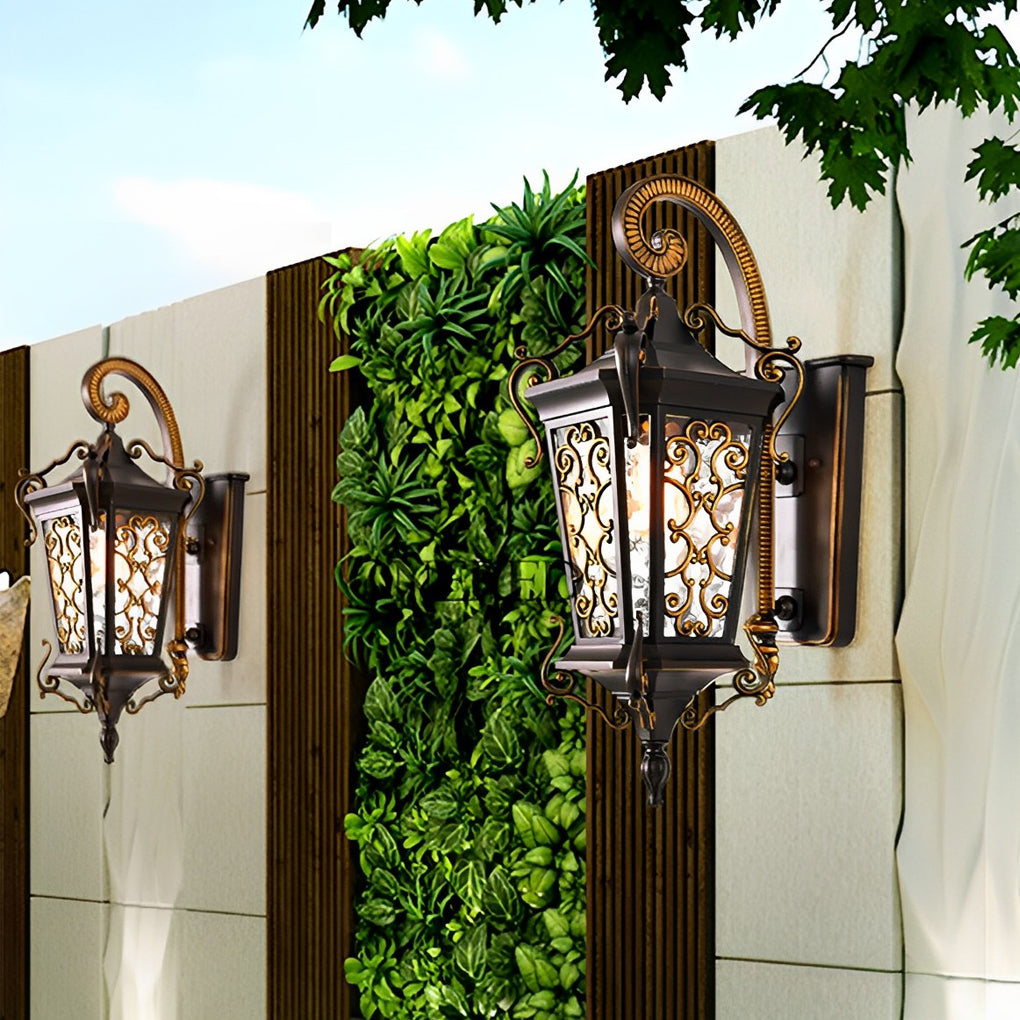 Antique style exterior wall sconce mounted on stone wall, featuring carved metal details and warm illumination.