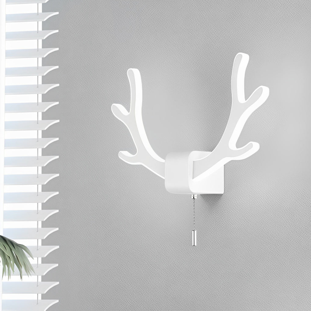 Antler wall sconce light displayed on a textured wall near a window, providing accent lighting with a modern rustic touch.