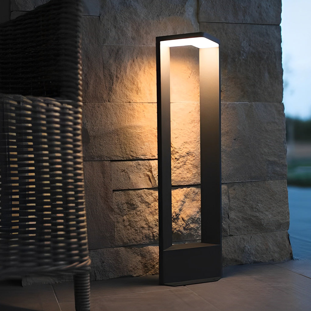 Architectural garden path light illuminating a warm textured stone block wall on a home patio.