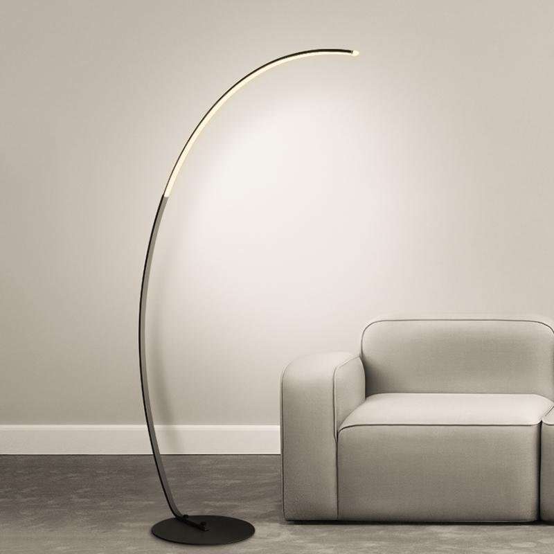 Arcing floor lamp with a curved design, providing ambient lighting in a modern interior.