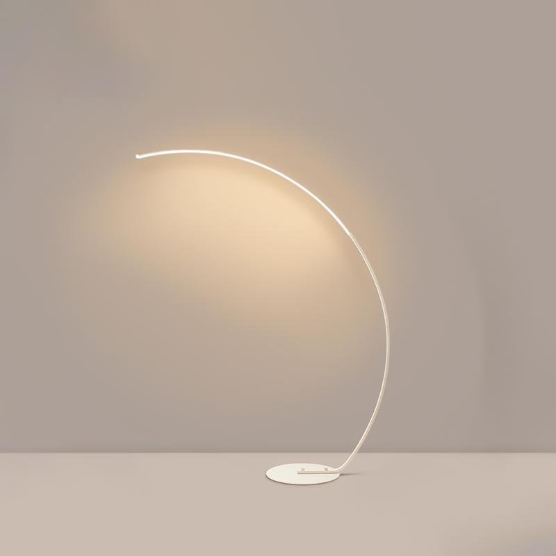 Arcing floor lamp with a sleek curved design, providing ambient light in a modern room.