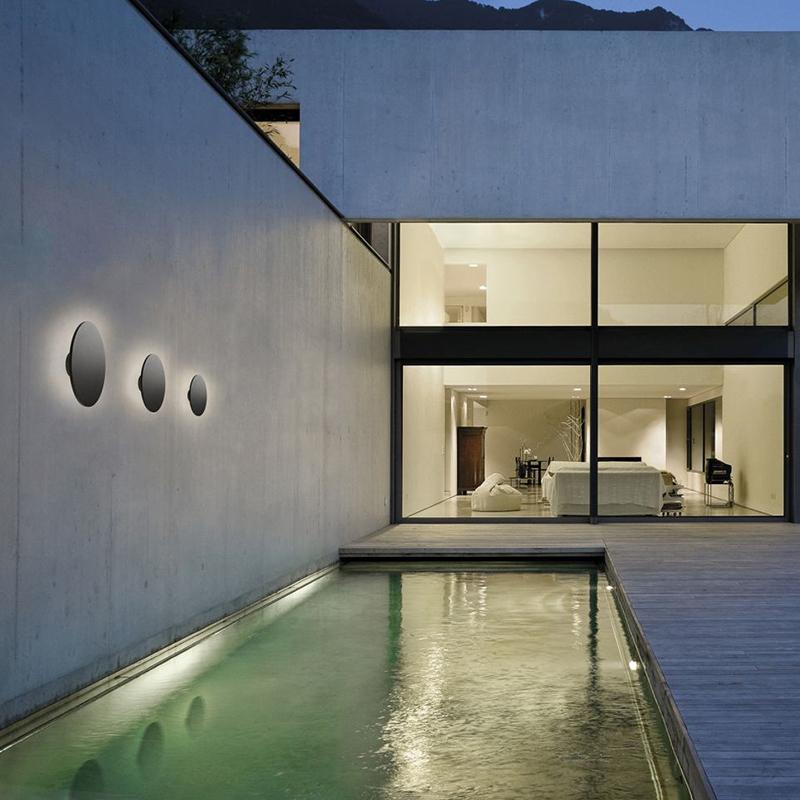 Backlit wall light installed along outdoor poolside wall