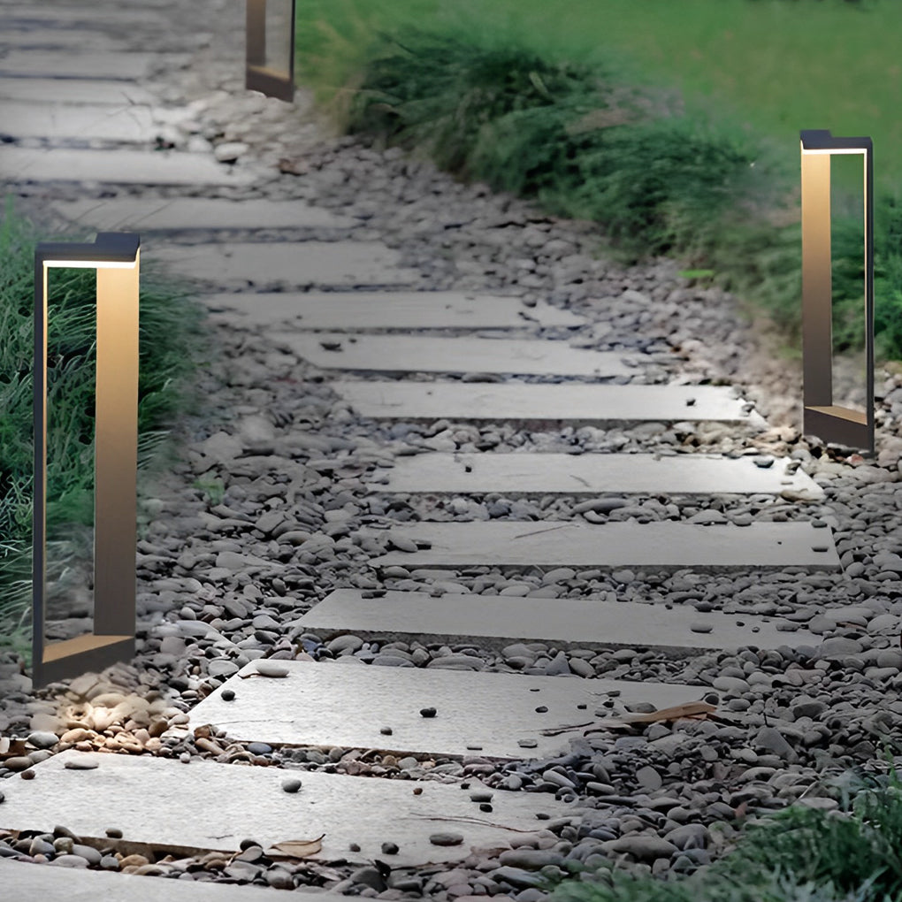 Beautiful architectural garden path lights illuminating a stone stepping walkway set in gravel.