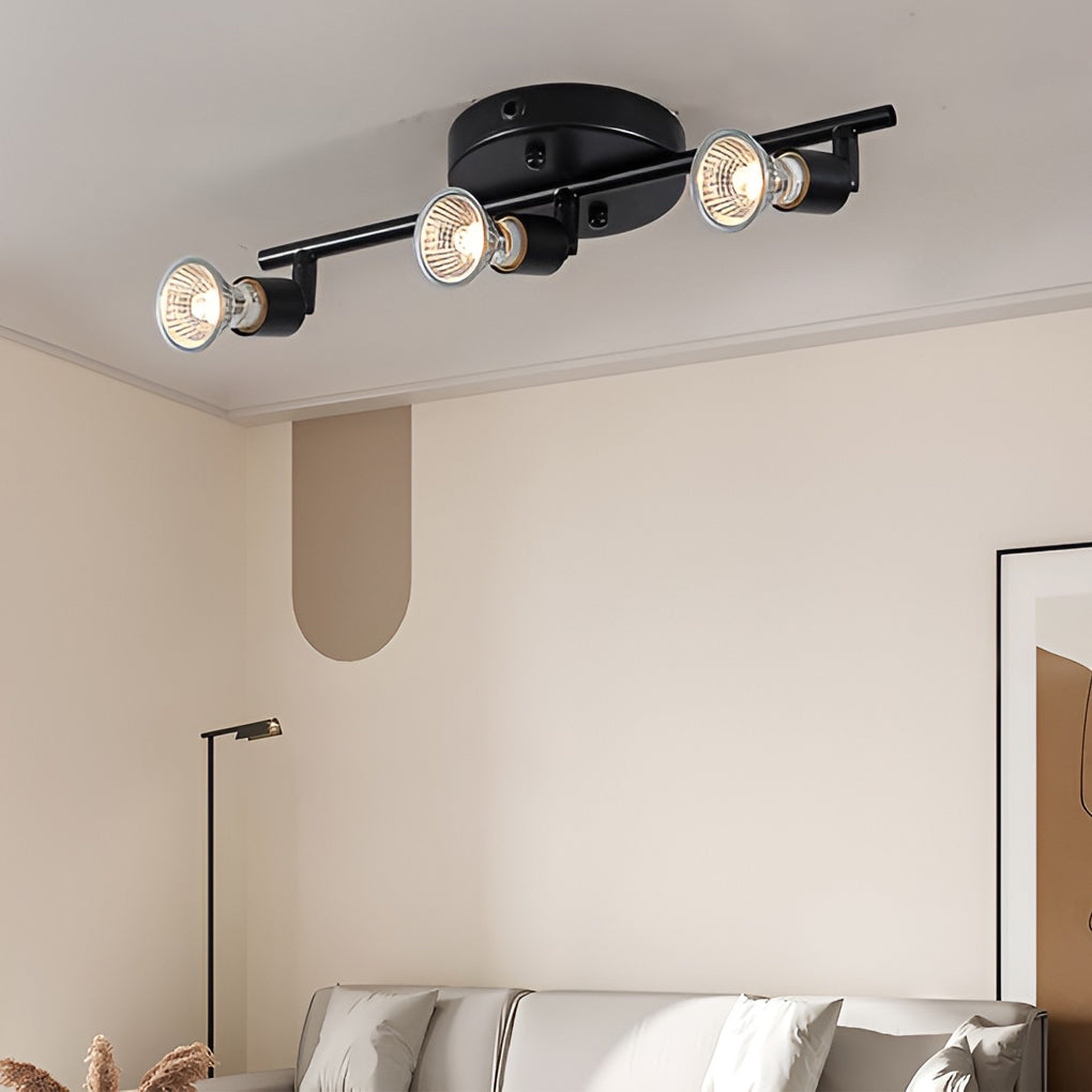 Black adjustable ceiling lights mounted above a bed, offering directional lighting in a minimalist bedroom interior.