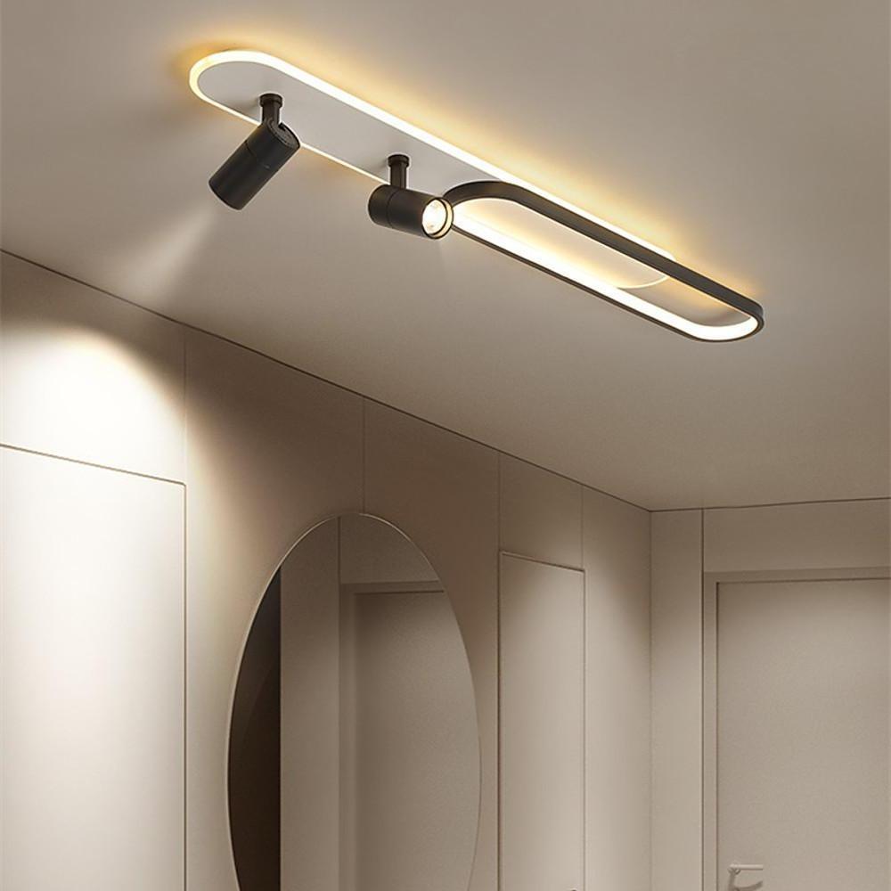 Black adjustable spotlights mounted on ceiling with curved LED light strip.