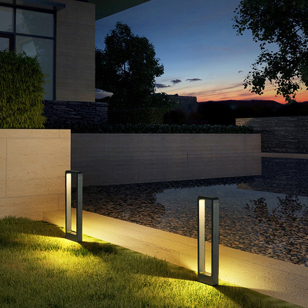 Black bollard lights providing soft light along a modern driveway at dusk.
