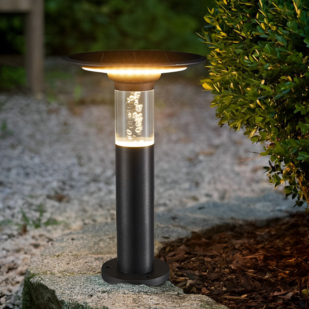 Black brass path lights enhancing a modern outdoor seating area with warm light.