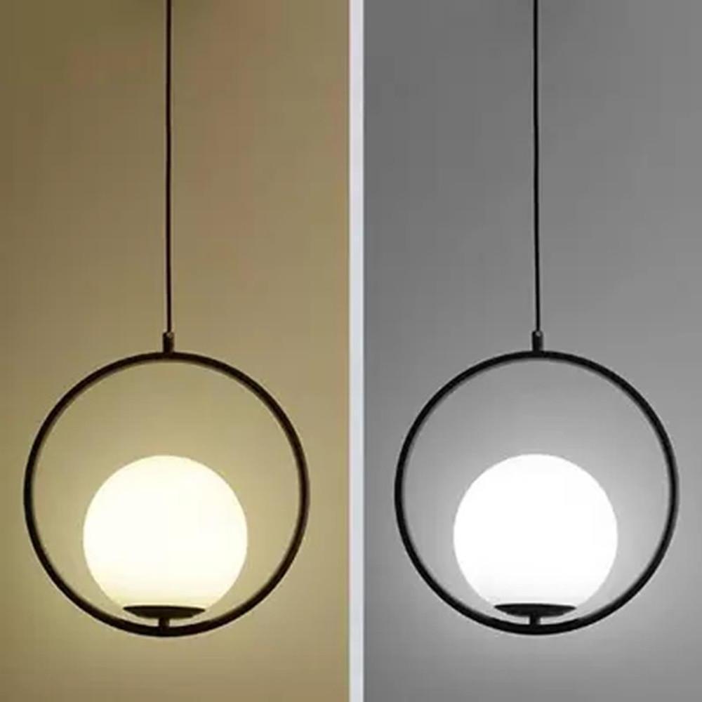 Black minimalist hanging lamp with a circular frame shown in warm and cool lighting options.