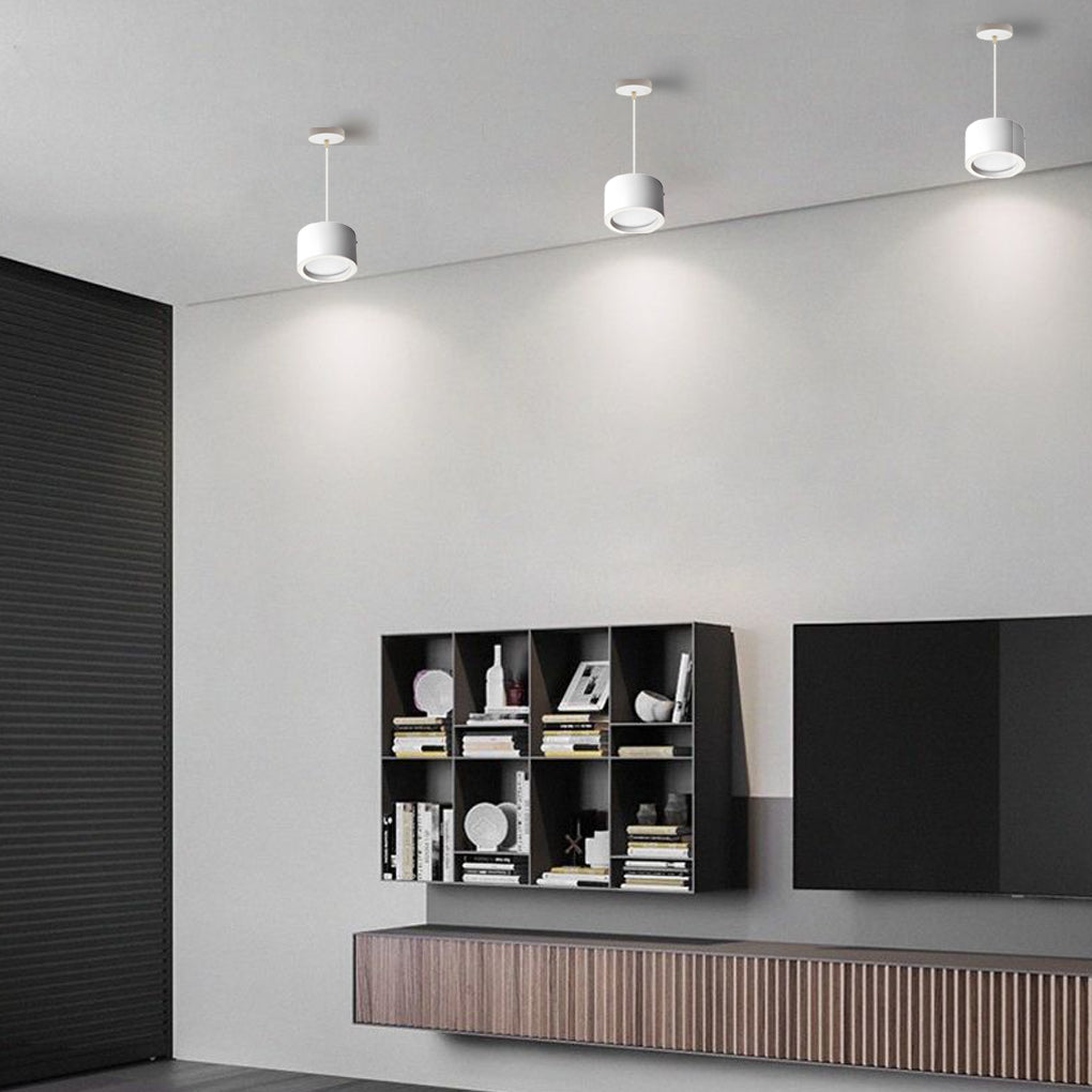 Black drum pendant light illuminating a minimalist bar area with focused glow.