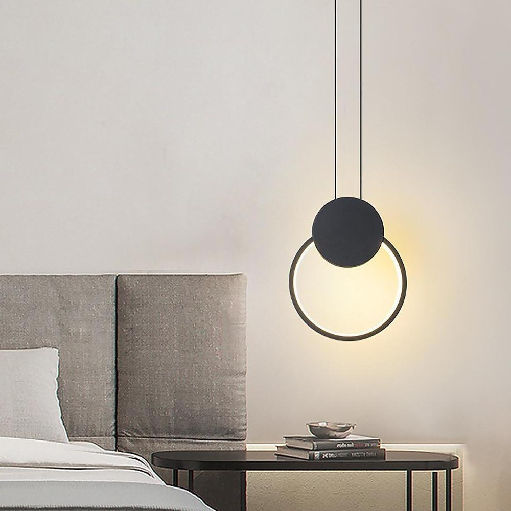 Single black geometric pendant light above bedside table in minimalist bedroom.