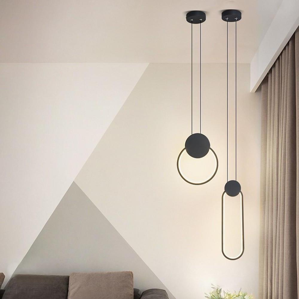 Black geometric pendant lights hanging at different heights in modern living space.