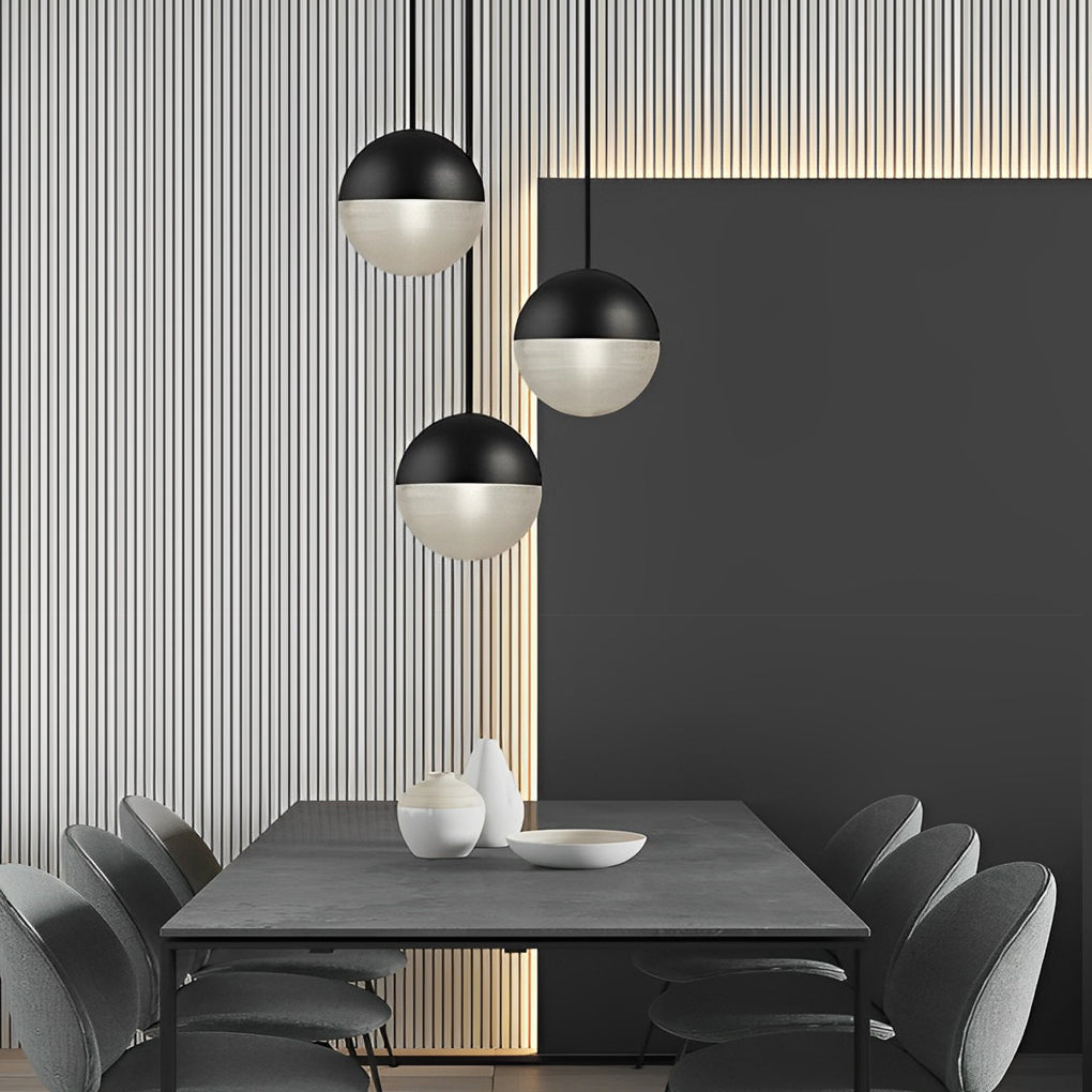 Cluster of black globe pendant light globes above a dark grey dining table in a modern room.