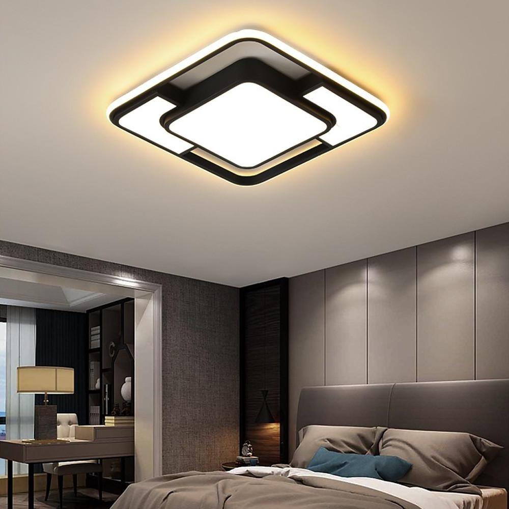 Black and gold square flush mount ceiling light in a modern bedroom interior