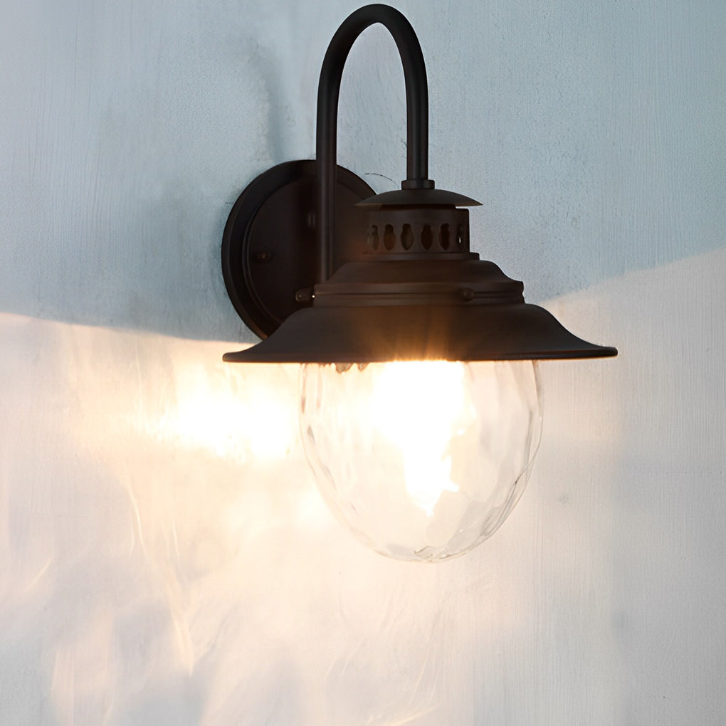 Black gooseneck wall light shining on exterior wall surface, vintage style outdoor lighting creating soft decorative glow.