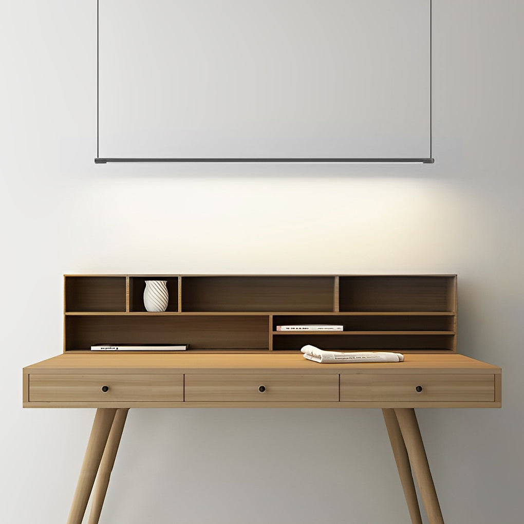 Black linear pendant light fixture suspended in minimalist architectural space.