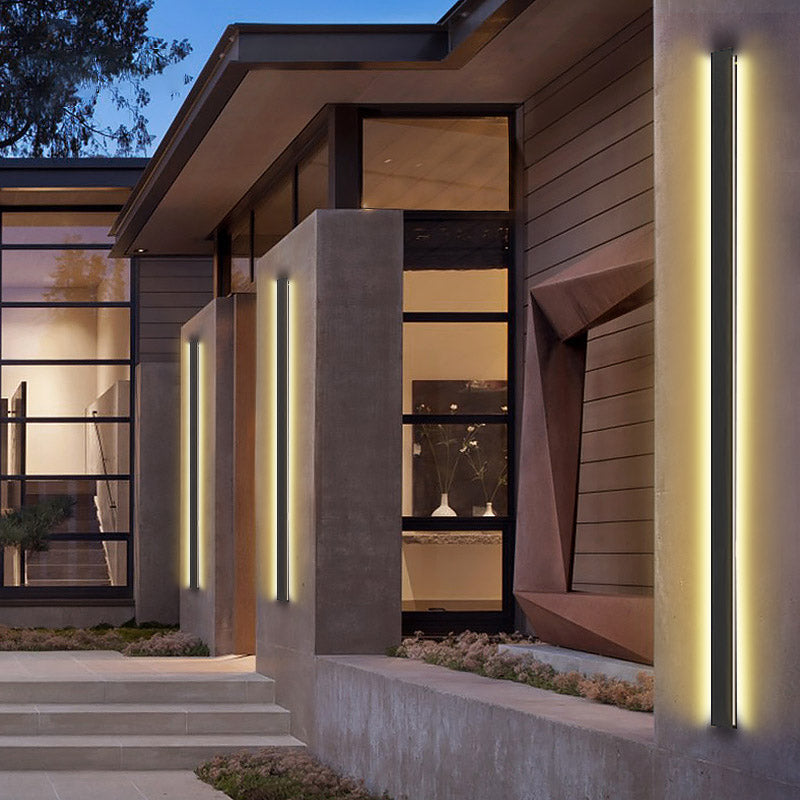 Black linear wall light providing ambient light along a stylish patio.
