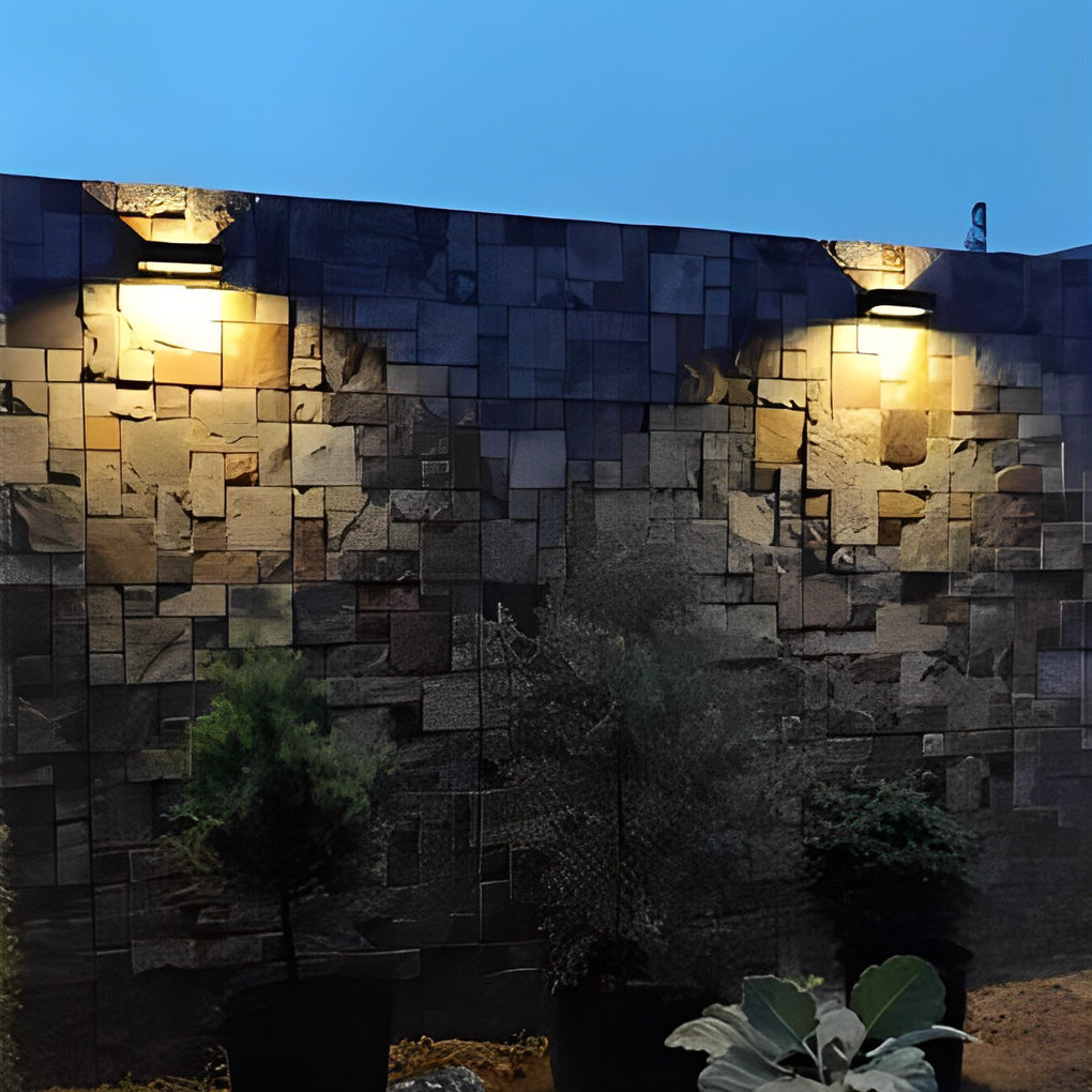 Black motion sensor outdoor wall light enhancing a modern house exterior with warm light.