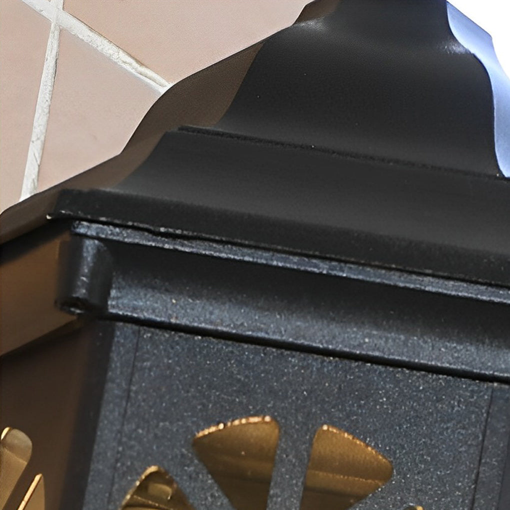Black outdoor lantern sconce with a close-up of the intricate glass and metal design.