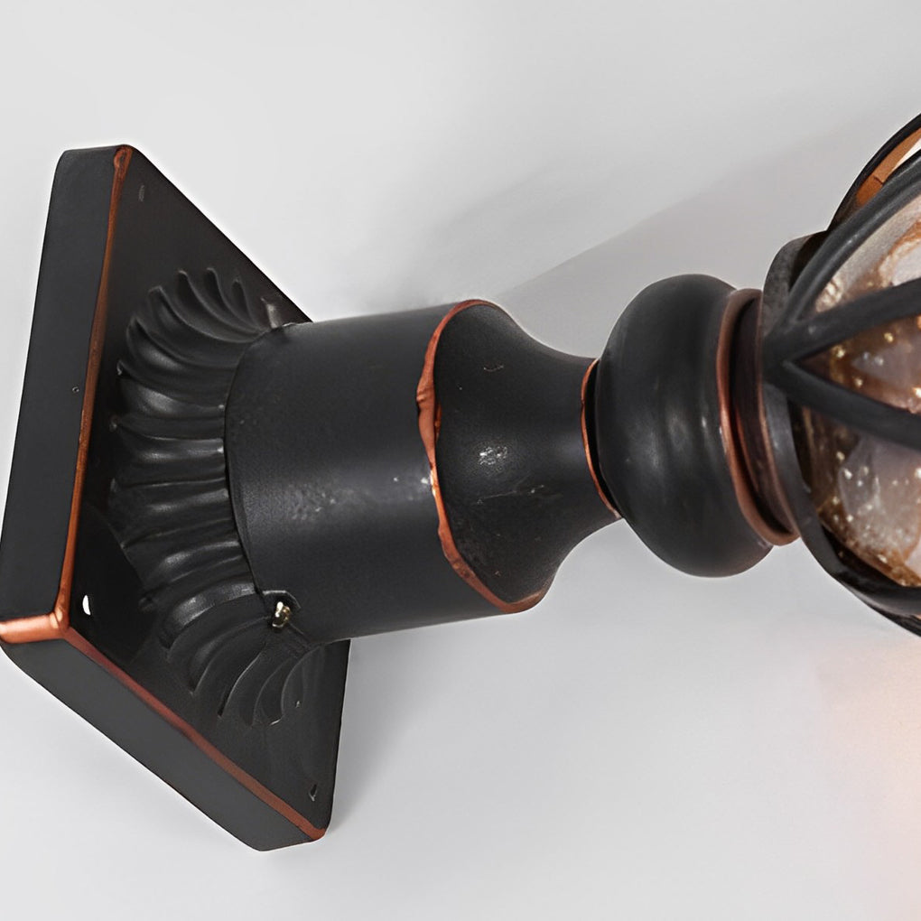 Black outdoor pillar light with a close-up of the decorative top finial and glass panels.