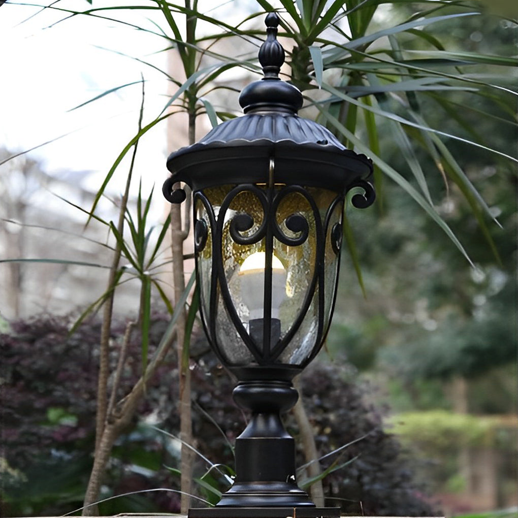 Detailed view of a black outdoor pillar light base with intricate scrollwork and copper accents.