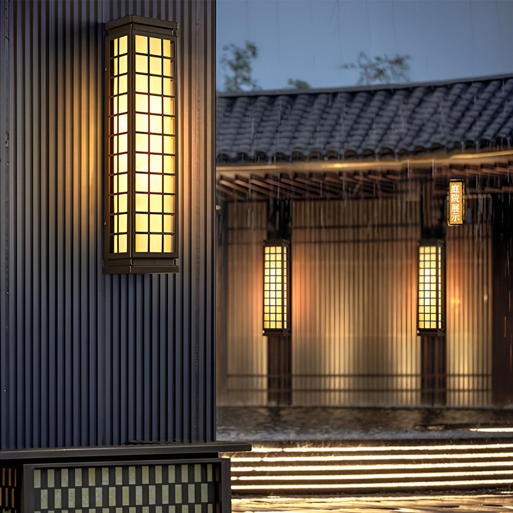 Black outdoor sconce light featuring grid design on traditional wooden building exterior.