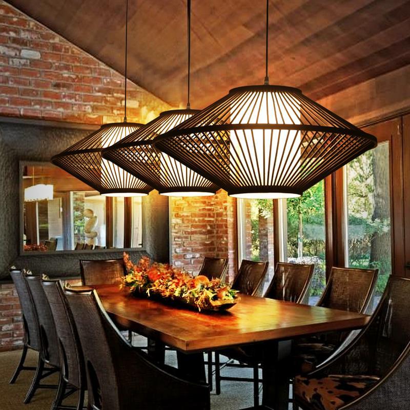 Black rattan pendant light with a woven design, illuminating a contemporary kitchen island.