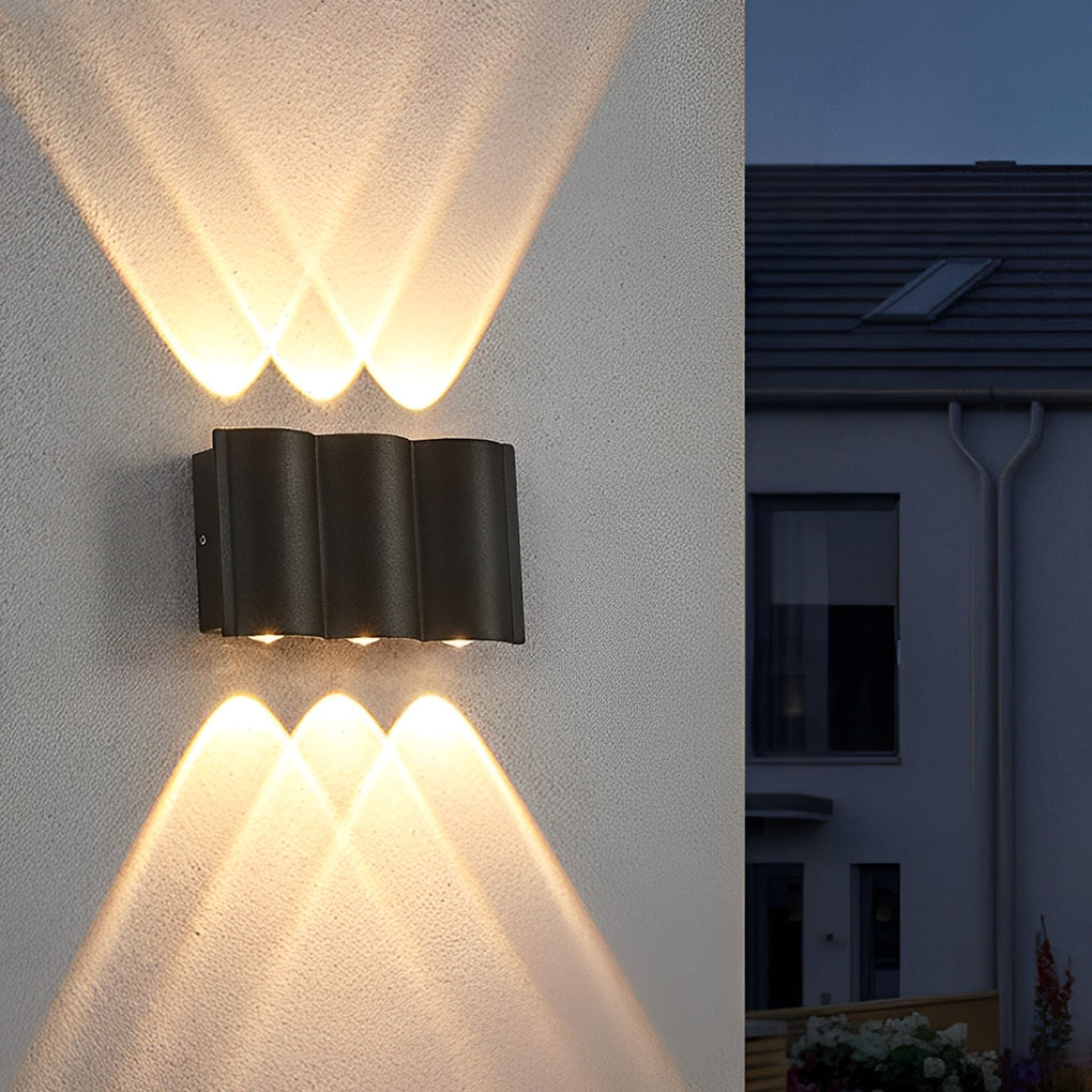 Black up and down outdoor wall lights providing symmetrical lighting on smooth gray exterior wall.