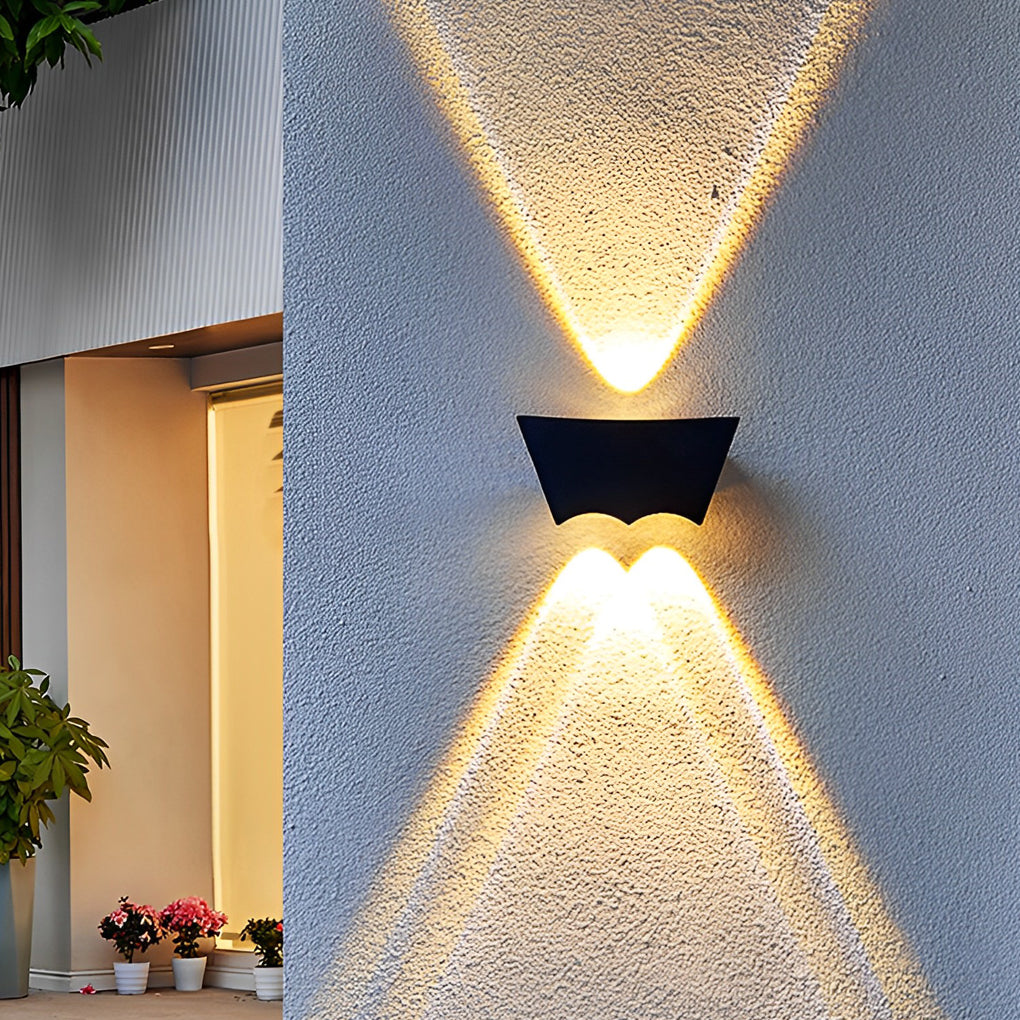 Black up down wall light close-up on textured wall, showing sharp triangular light patterns directed upward and downward.