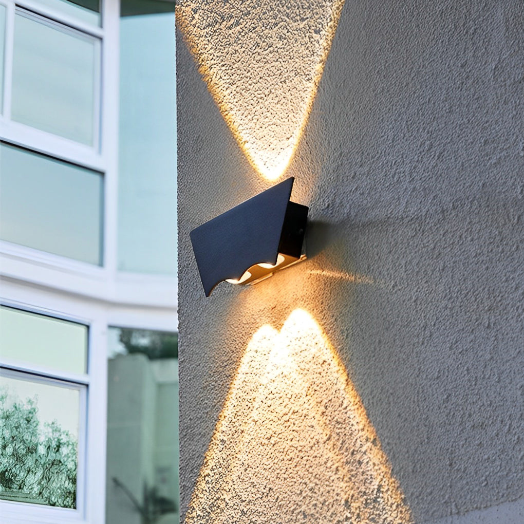 Black up down wall light installed near a window, adding decorative exterior lighting with focused up and down beams.