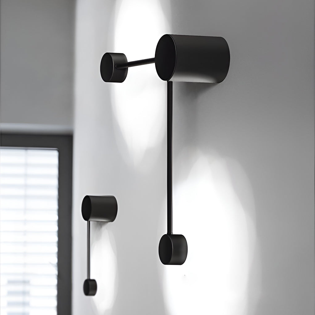 Black wall light illuminating a minimalist interior with focused glow.