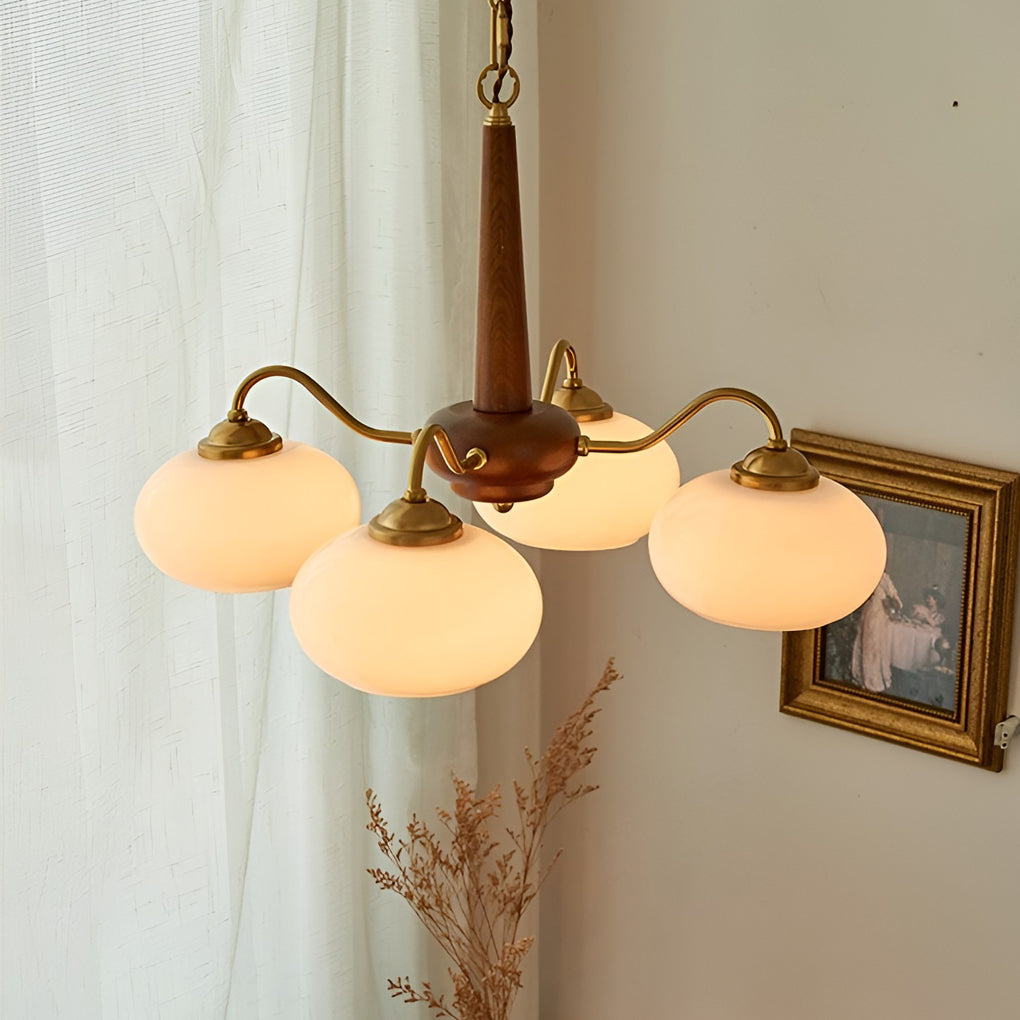 Black walnut brass chandelier enhancing a modern dining table with warm light.