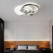Black and white ceiling fan with integrated LED light installed in a modern bedroom.