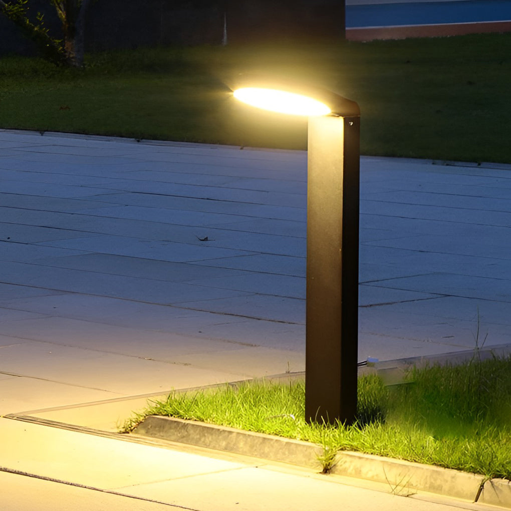 Bollard landscape lights providing soft illumination along a stylish driveway.