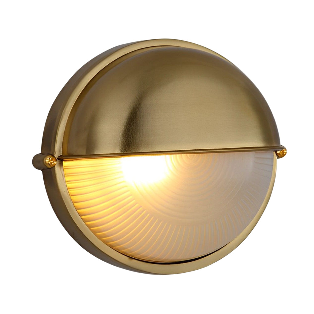 Brass oval bulkhead wall light with warm illumination showcased on a plain background.