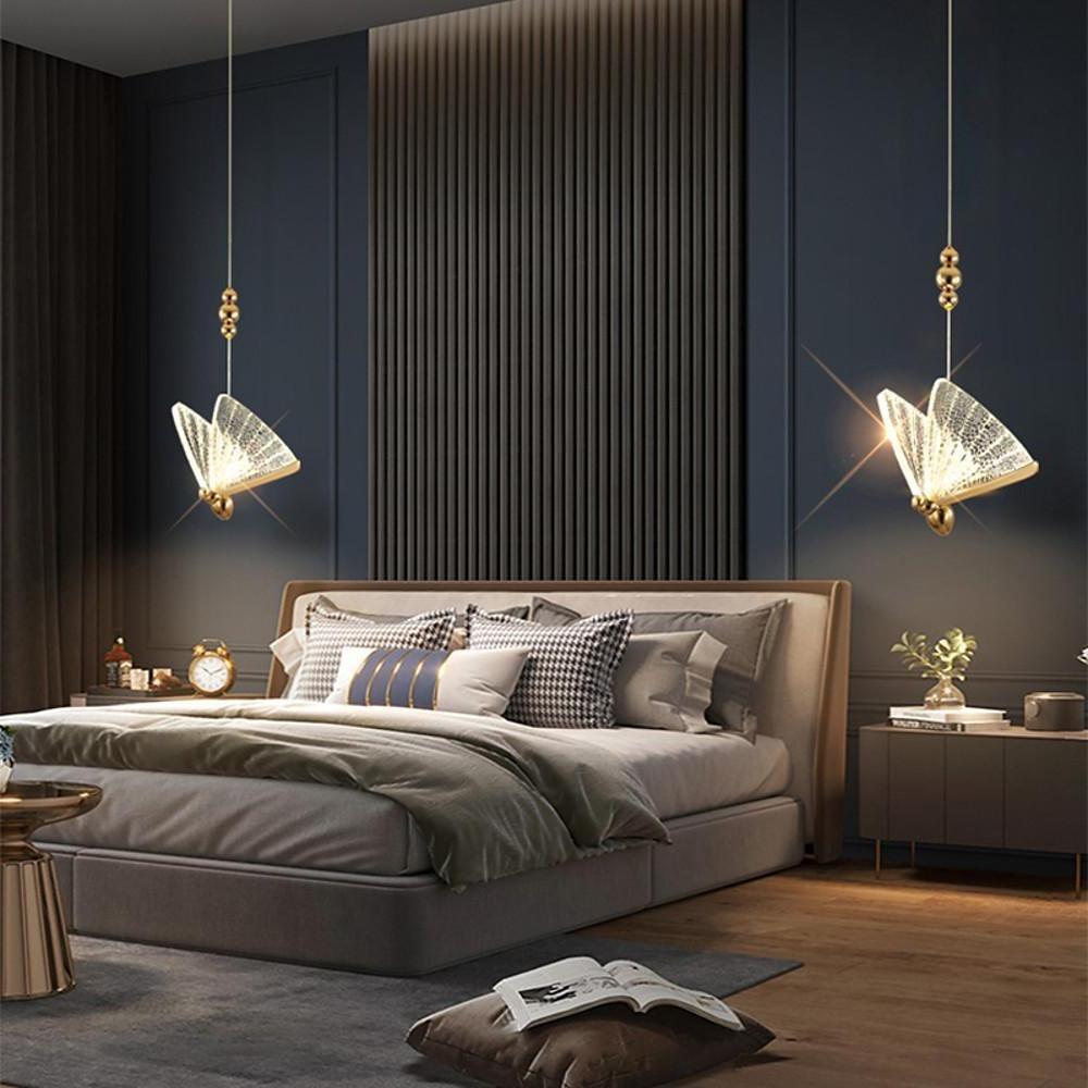 Butterfly pendant lights installed symmetrically above bed in modern bedroom interior.