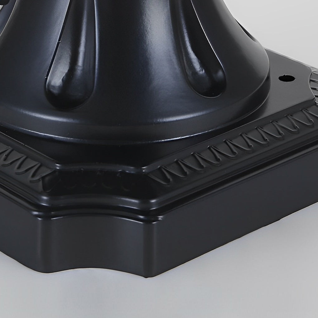 Cast aluminum post light with bronze finish and frosted glass, adding charm to a landscaped garden.