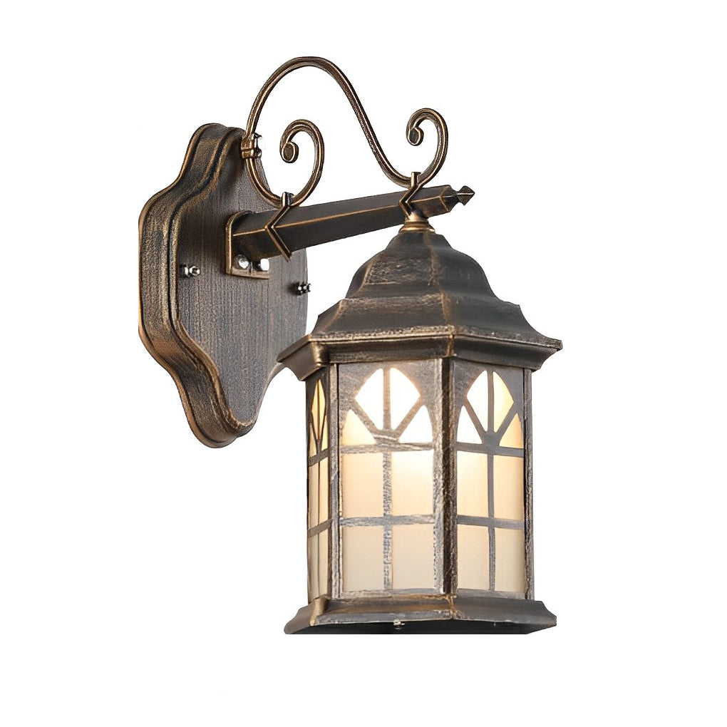 Classic porch light in bronze with decorative scroll arm and frosted glass, illuminating a cozy patio seating area.