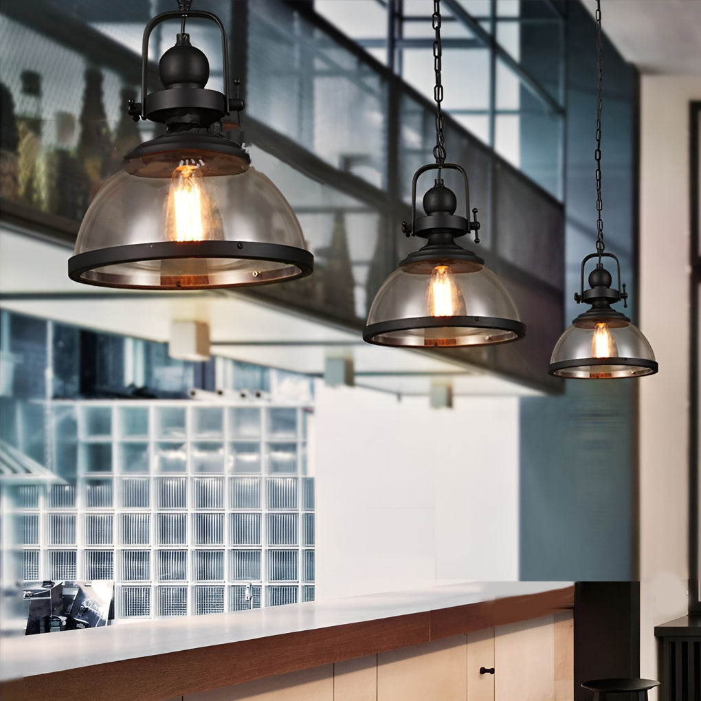 Multiple clear glass pendant lighting fixtures in a row